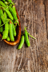 Green peas in a wooden bowl.