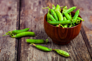 Green peas in a wooden bowl.