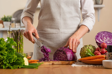 The chef cuts, chops fresh purple lettuce salad. The concept of losing healthy and wholesome food, detox, vegan eating, diet, cooking. Slow food, comfort food, healthy diet, clean eating