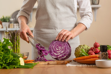 The chef cuts, chops fresh purple lettuce salad. The concept of losing healthy and wholesome food, detox, vegan eating, diet, cooking. Slow food, comfort food, healthy diet, clean eating