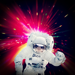 Astronaut in suit against galaxy splash, motion hyperjump. The elements of this image furnished by...