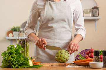Chef preparing artichoke. The concept of losing healthy and wholesome food, detox, vegan eating,...