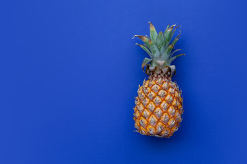 Summer scene. Pineapple on blue background. Concept of holiday on beach, travel, minimalist bright colors, summertime. Flat lay. Copy space