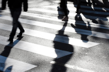 Blurry zebra crossing with pedestrians making long shadows - 276103674