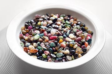 Stone beads from tourmaline in a white plate.