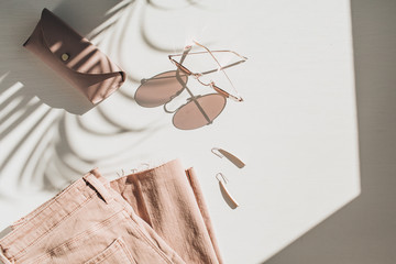 Fashion composition with women's clothes and accessories on white background. Earrings, sunglasses,...