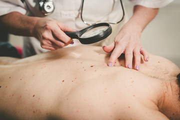 Dermatologist examining the skin of a patient