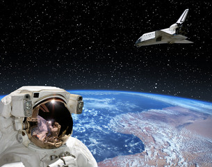 Astronaut looking at shuttle that flies in space. The elements of this image furnished by NASA.