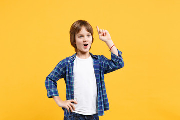 Fun cheerful happy little kid boy in blue shirt white t-shirt posing gesturing hands isolated on yellow wall background children studio portrait. People childhood lifestyle concept. Mock up copy space