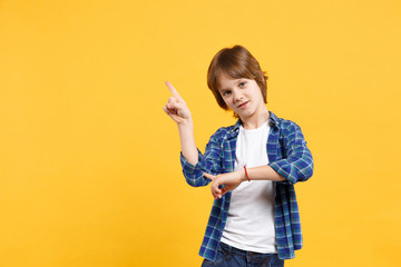 Fun cheerful happy little kid boy in blue shirt white t-shirt posing gesturing hands isolated on yellow wall background children studio portrait. People childhood lifestyle concept. Mock up copy space