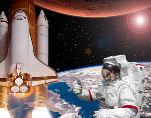 Rocket flies from earth to Mars. Astronaut shows the thumbs-up. Big sun.  The elements of this image furnished by NASA.