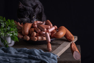  black cat eating sausages on the table