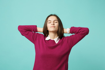 Young brunette woman girl in casual clothes posing isolated on blue turquoise background studio portrait. People sincere emotions lifestyle concept. Mock up copy space. hold hands behind head relax.