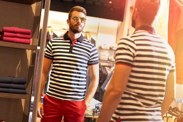 Young man reflected in the mirror in new summer collections