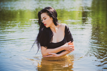 Fototapeta premium Vacation time. Woman in black swimsuit at summer days 