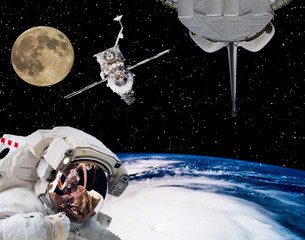 Astronaut in outer space, moon and spaceships on the backdrop. The elements of this image furnished by NASA.