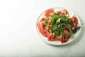 Homemade beef carpaccio with pesto sauce