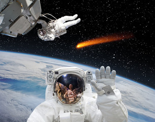 Astronaut waving in front. Comet on the background. The elements of this image furnished by NASA.