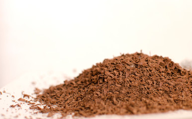 Heap of grated chocolate on the white background