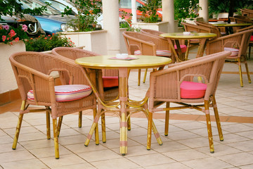 Fototapeta na wymiar Chairs and tables in outdoor restaurant. Patio in city in suny summer.