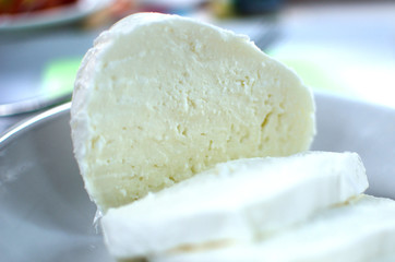 Cut of mozzarella on the white plate.