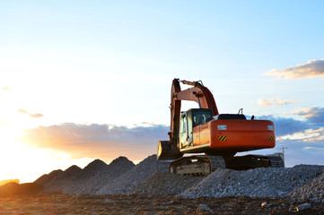 Large tracked excavator works in a gravel pit. Loading of stone and rubble for its processing at a...