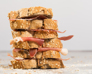 tiered sandwich made with with rye bread and ham