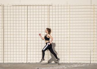 Young woman running outdoors with sportswear