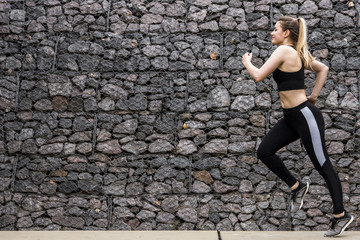 Young woman running outdoors with sportswear