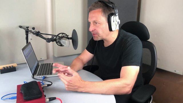 Male radio presenter podcaster recording in studio