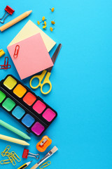 Colorful school stationery and supplies on blue background.