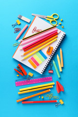 Set of various colorful school stationery on blue background.