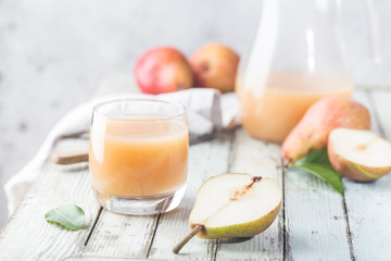 Fresh Pear Juice in a glasses with fresh fruits on light background