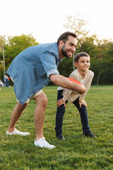 Two cheerful brothers playing frisbee on the lawn