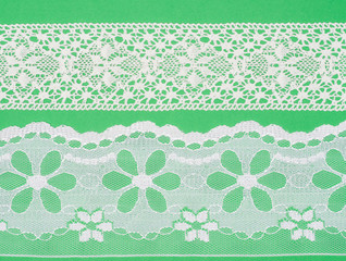 White lace on green background. Lacework concept