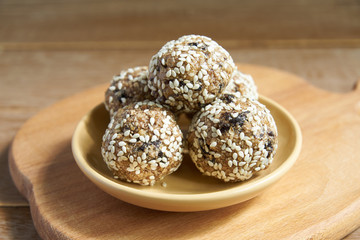 Homemade Healthy vegan Raw Energy  Balls with sesame on wooden cuttng board.