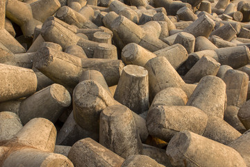 pile of old gray concrete tetrapods close up, tsunami barrier