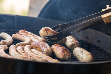 Cooking sausages on the barbecue grill. Grilled sausages. 
