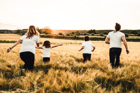 Happy family running through the countryside. Family having fun field