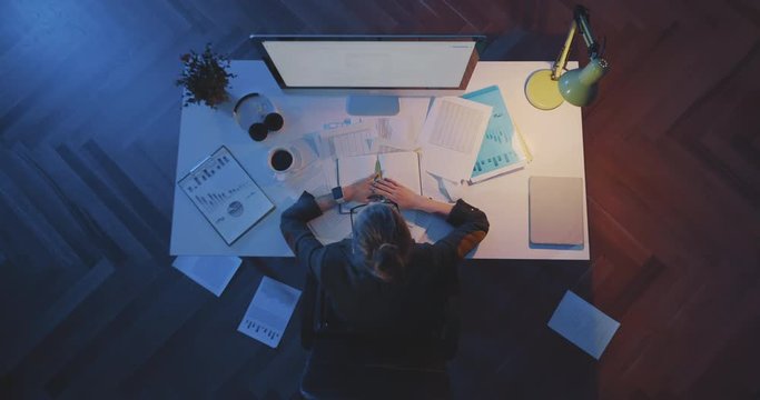Young Businesswoman Sleeping On Desk At Workplace