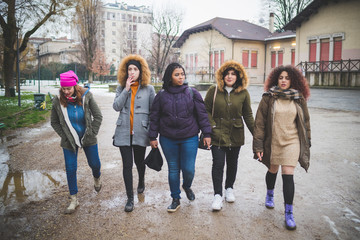 group of young women walking in the street, smoking and having conversation