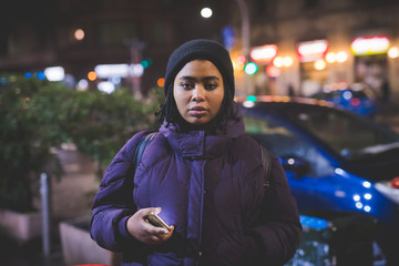 portrait of young african woman standing outdoor and looking camera
