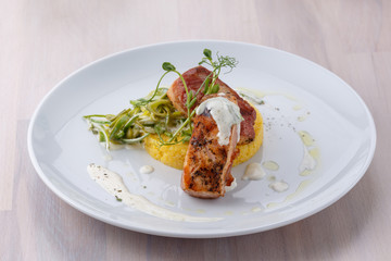 salmon medallions wrapped in bacon on plate selective focus