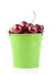 Cherries in green pail isolated on white