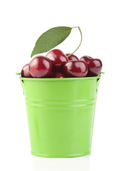Cherries in green pail isolated on white