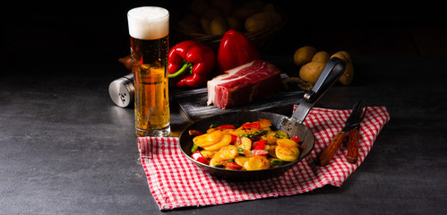 Fried potatoes with smoked bacon, green asparagus and paprika.