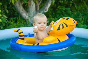 the child is swimming in an inflatable pool