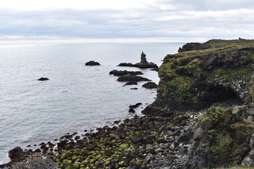 Hiking trail from Anarstapi to Hellnar with the raw ocean und big rocks and mountains in the west of Iceland at Snaefellsnes Peninsula