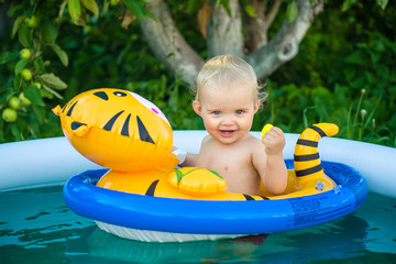 the child is swimming in an inflatable pool