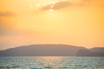 Beautiful landscape of sunset with pastel sky over calm sea and hills